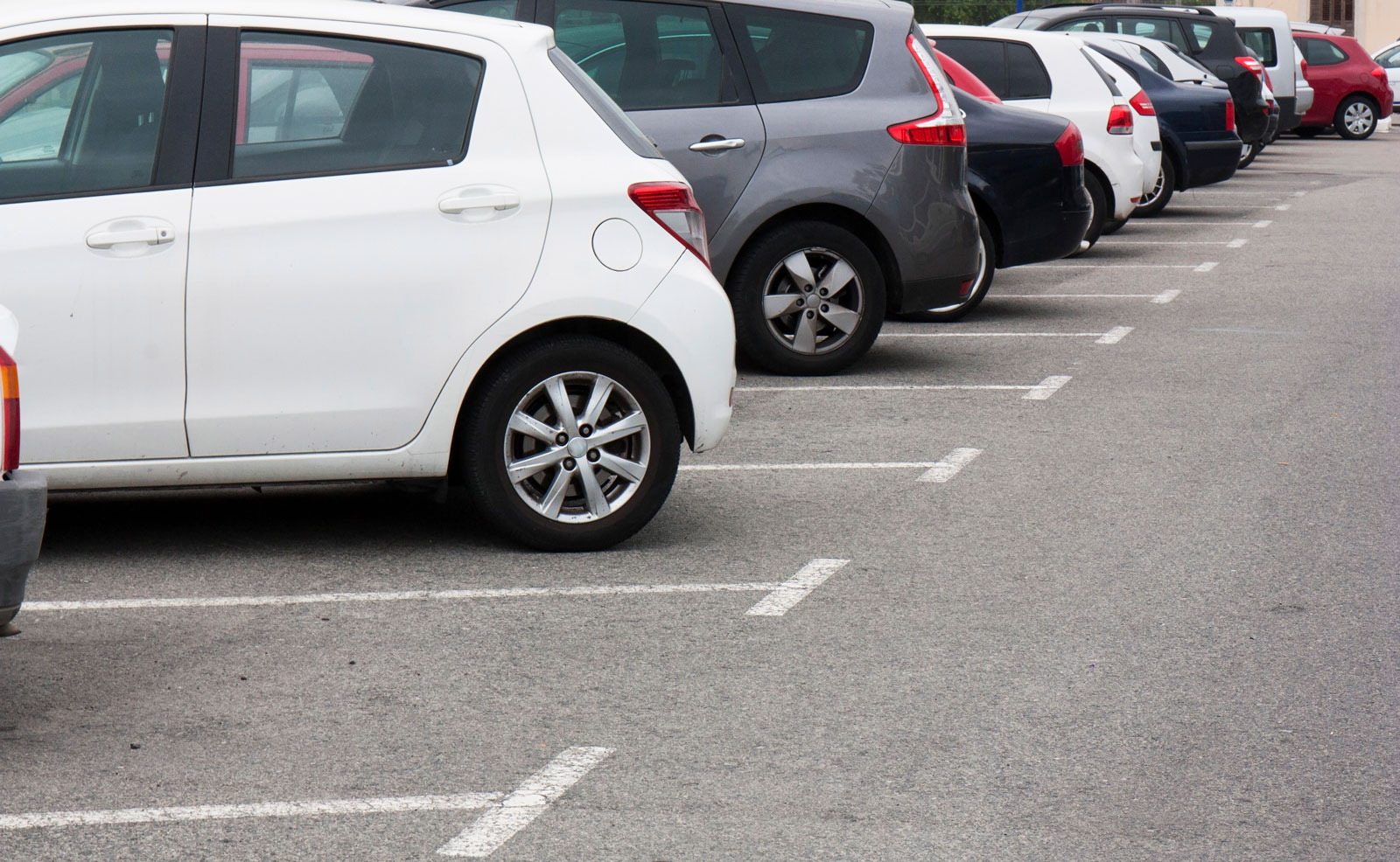 Cars parked in a municipal parking lot with clearly marked spaces